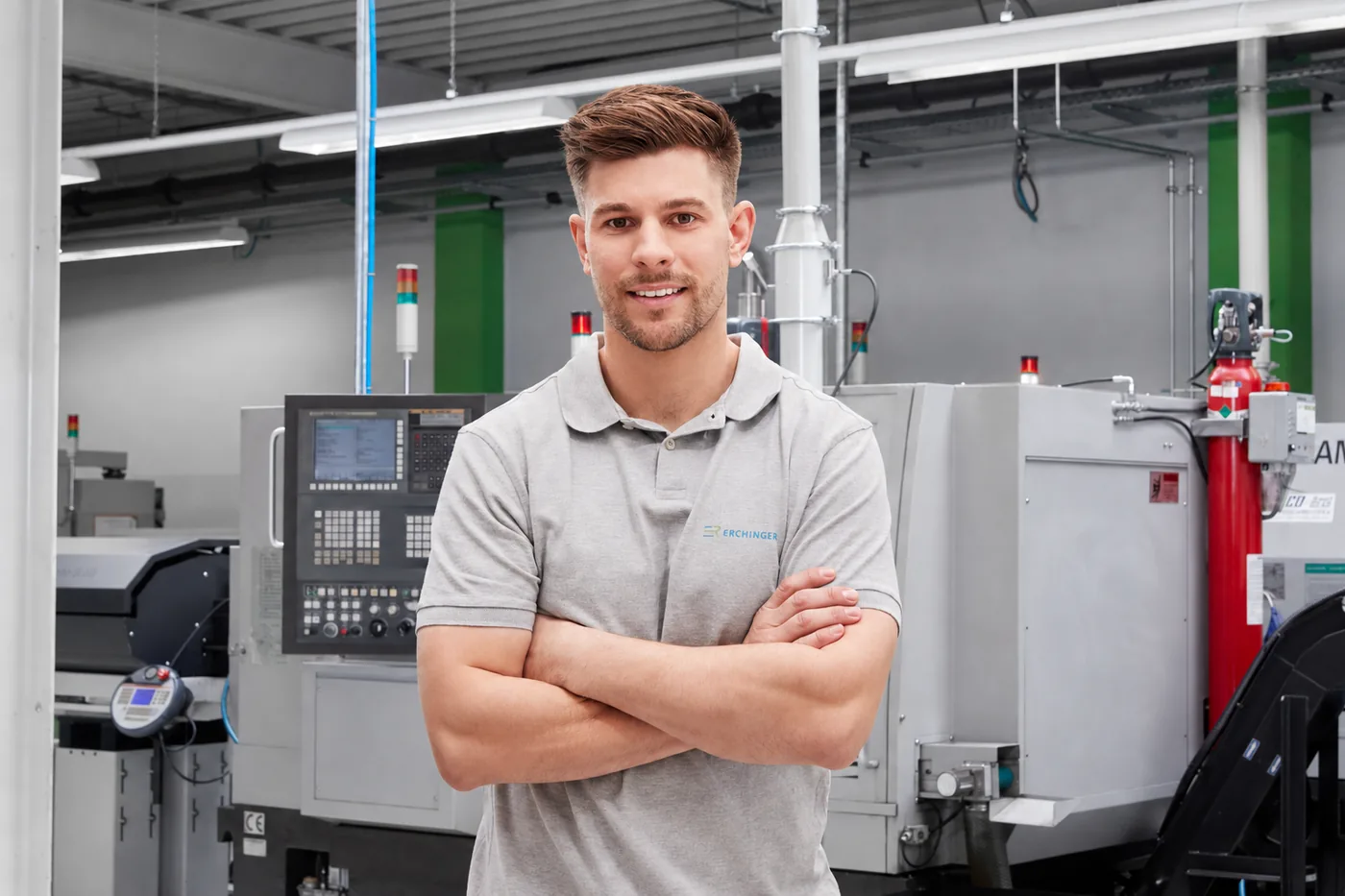 Mitarbeiter vor einer CNC-Drehmaschine in der Fertigung